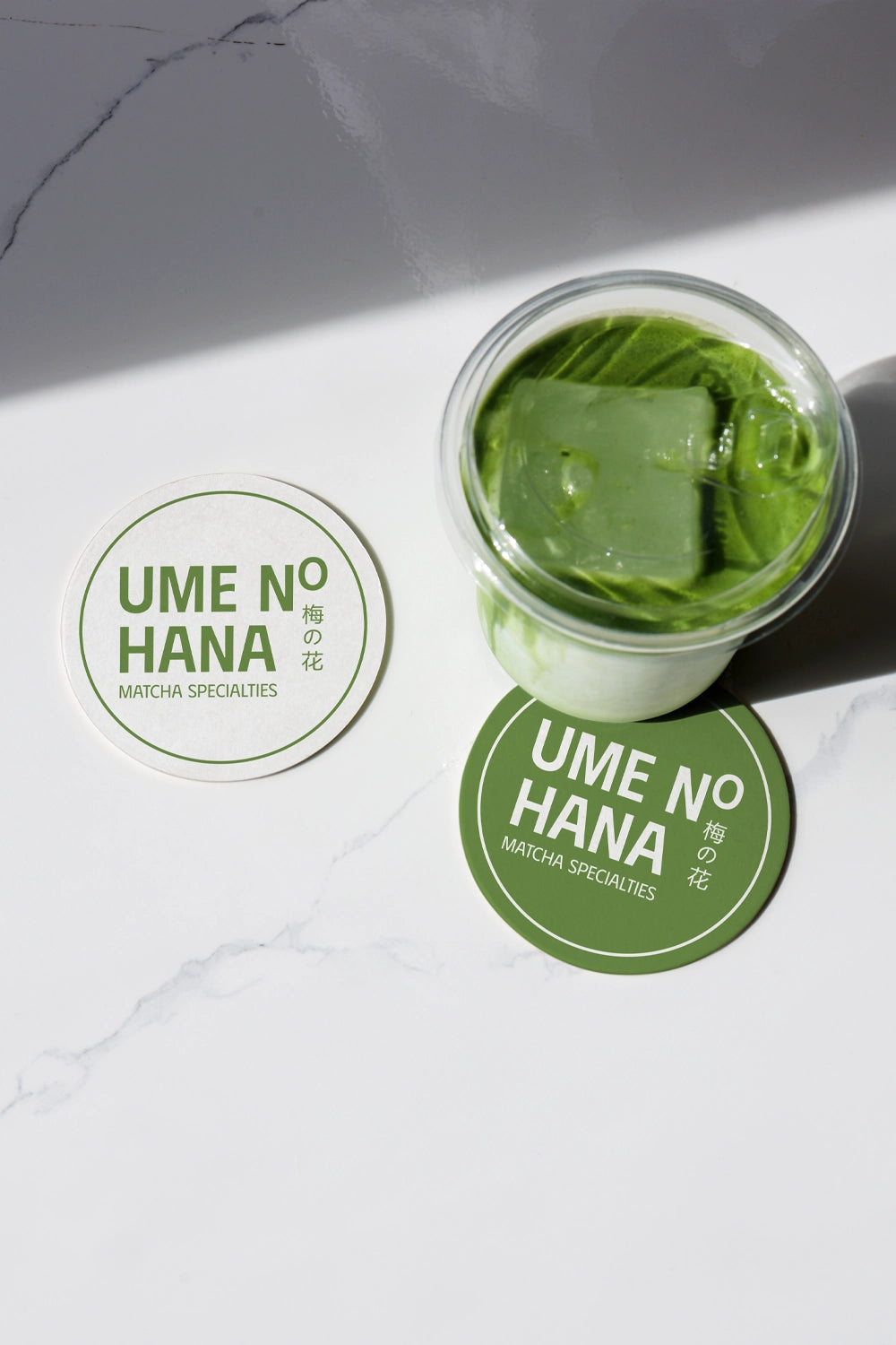 matcha beverage mockup with ice in glass jar and round label design, minimal flat lay scene