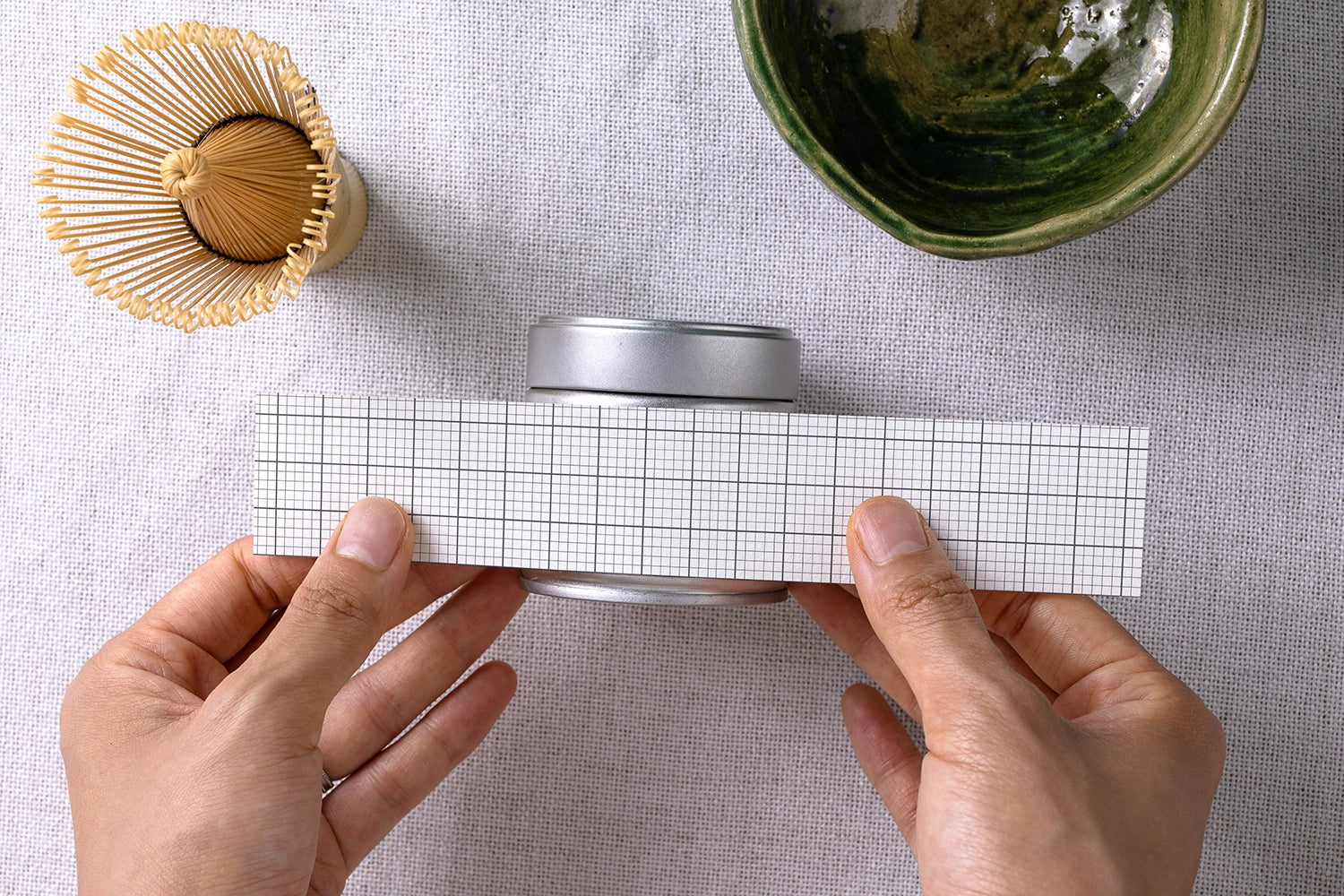 matcha tin label design mockup with hand interaction, minimal and realistic product scene