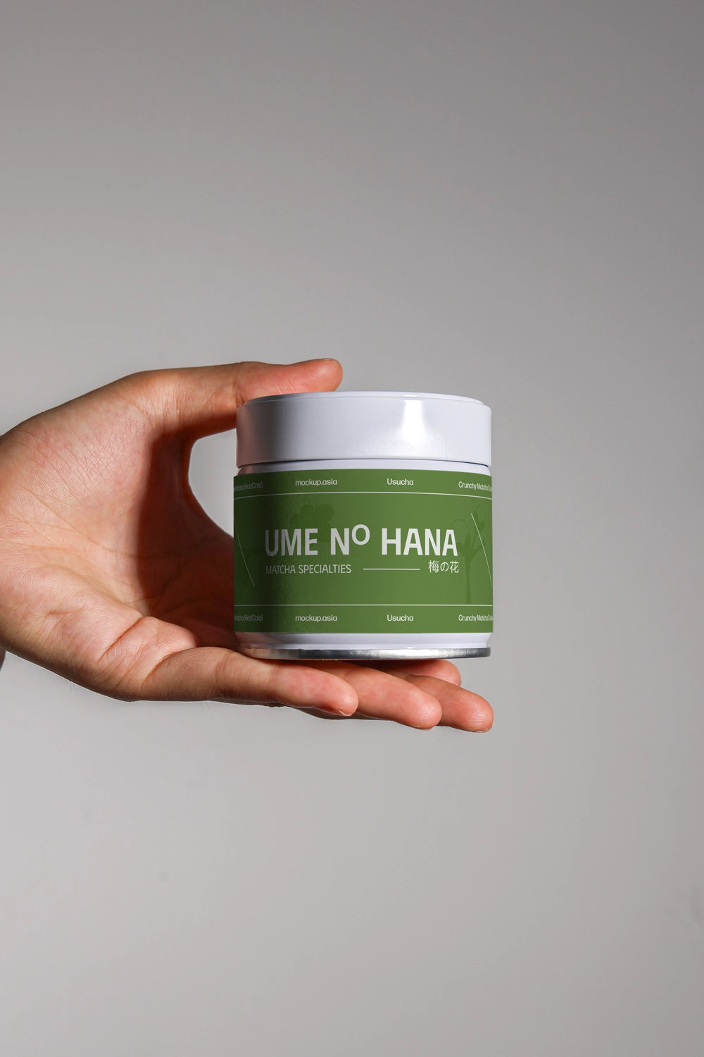 green tea matcha jar mockup with label held by hand, realistic product branding scene