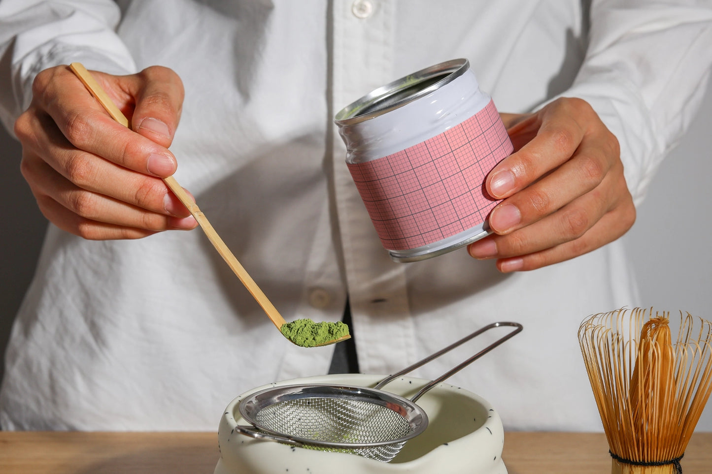 matcha tea packaging mockup with hands preparing powder, clean and minimal lifestyle setup