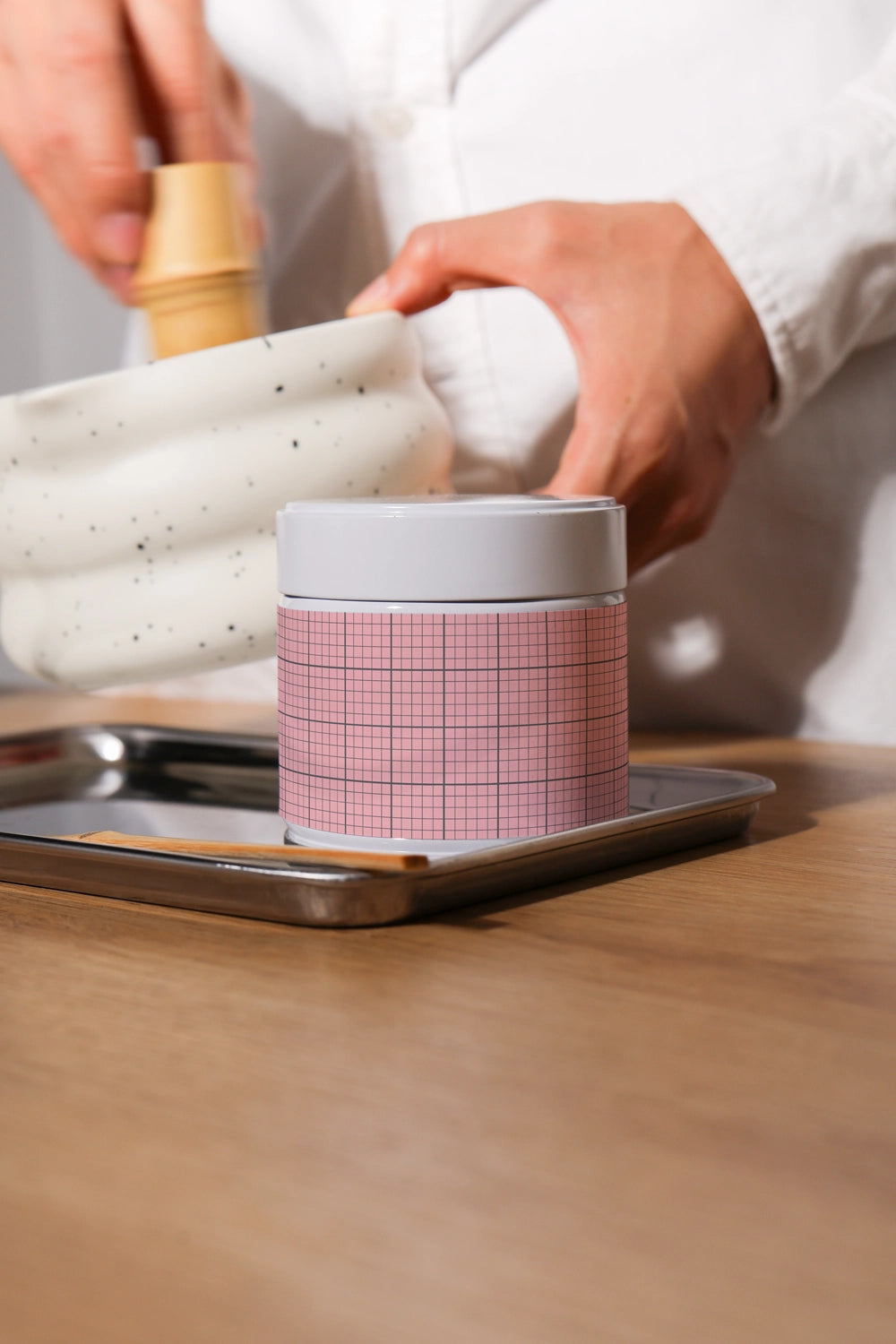 matcha packaging mockup in kitchen setup with ceramic bowl and tools, realistic product context