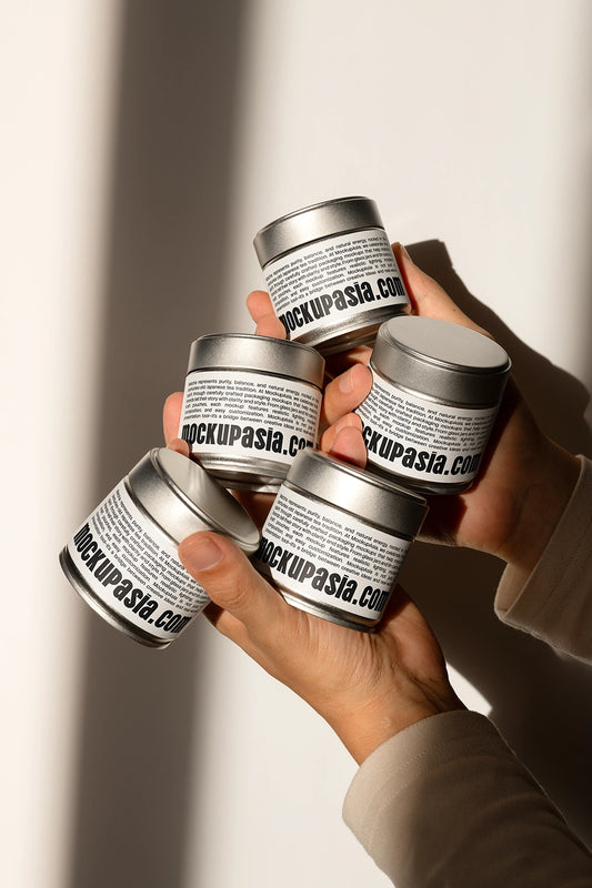 matcha tin can mockup set held in hands with natural sunlight, lifestyle packaging presentation