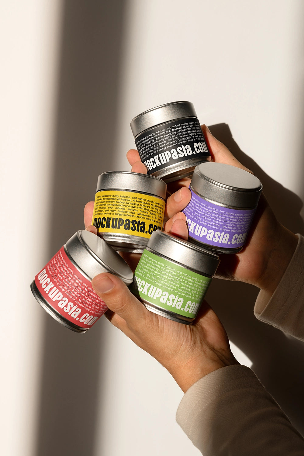 metal matcha tin container mockup set in hands with shadow lighting, minimal branding setup