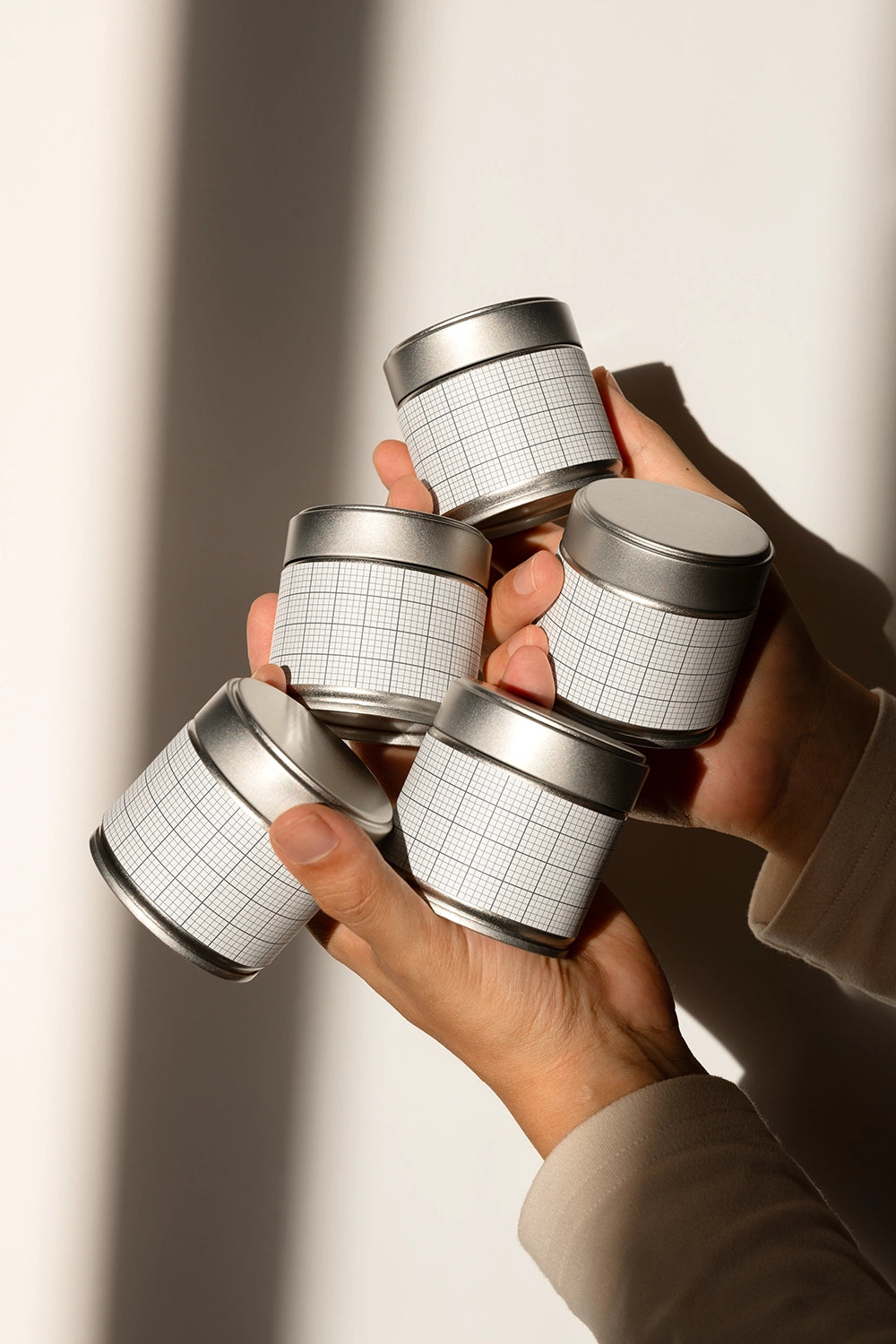 matcha tin packaging mockup bundle held by hands, natural light and product presentation