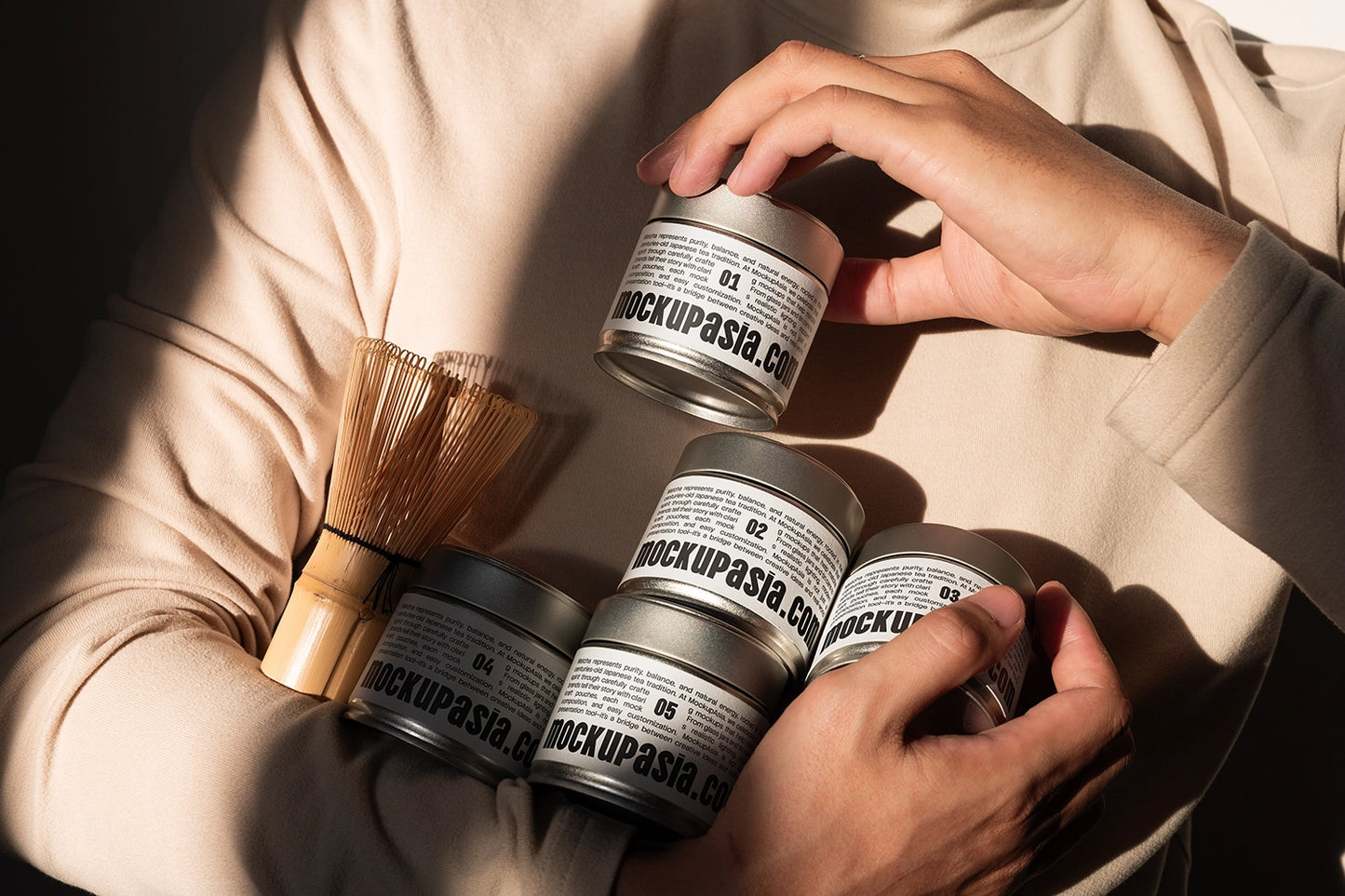 Realistic matcha tin can packaging mockup with editable labels, bamboo matcha whisk, and warm natural sunlight