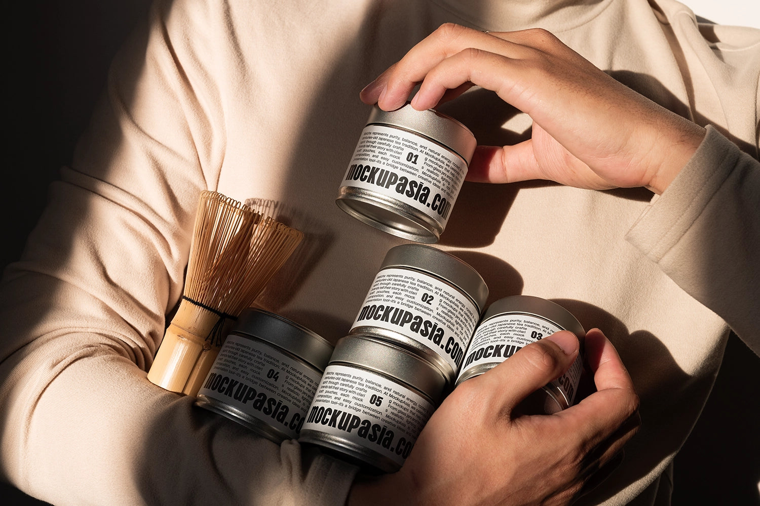 Realistic matcha tin can packaging mockup with editable labels, bamboo matcha whisk, and warm natural sunlight