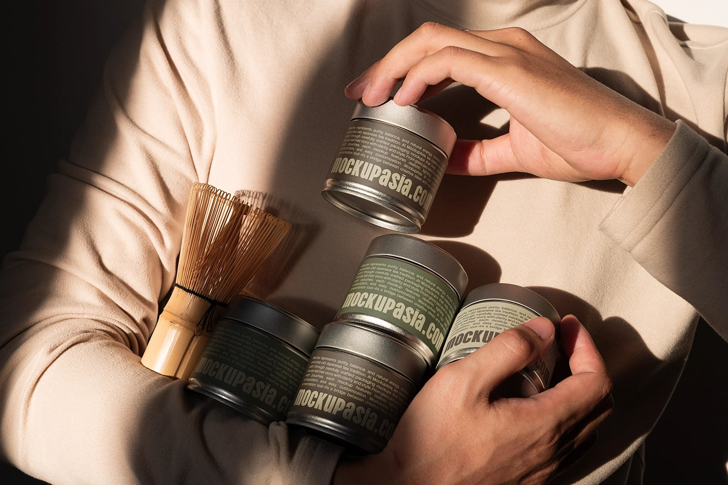 Realistic matcha tin can packaging mockup with editable labels, bamboo matcha whisk, and warm natural sunlight
