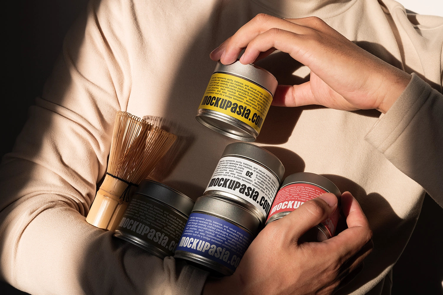 Realistic matcha tin can packaging mockup with editable labels, bamboo matcha whisk, and warm natural sunlight