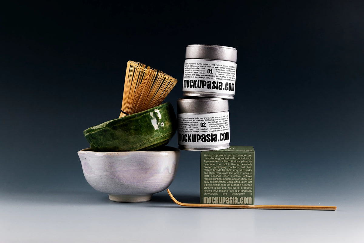 Premium matcha tin can mockup with stacked metal cans, ceramic matcha bowl, bamboo whisk, and dark studio background
