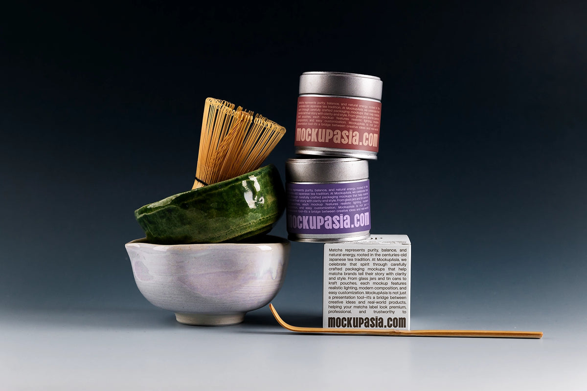 Premium matcha tin can mockup with stacked metal cans, ceramic matcha bowl, bamboo whisk, and dark studio background
