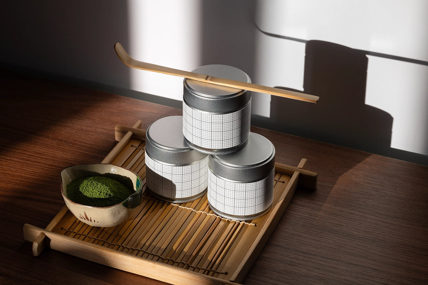 Editable matcha tin packaging mockup styled with traditional Japanese matcha accessories and dramatic natural lighting