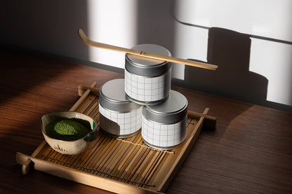 Editable matcha tin packaging mockup styled with traditional Japanese matcha accessories and dramatic natural lighting