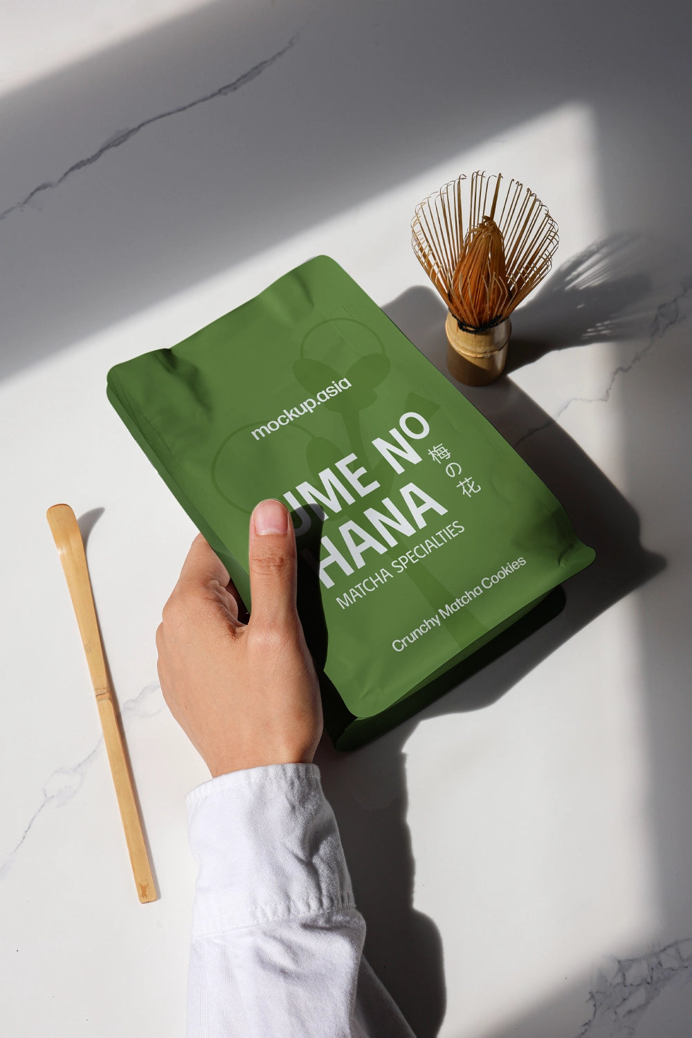 matcha tea packaging pouch mockup with dramatic shadow lighting, minimal lifestyle setup