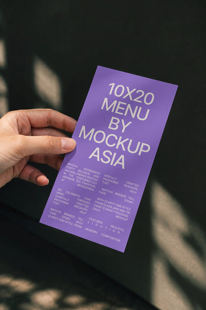 Menu card mockup PSD held in hand against dark green wall