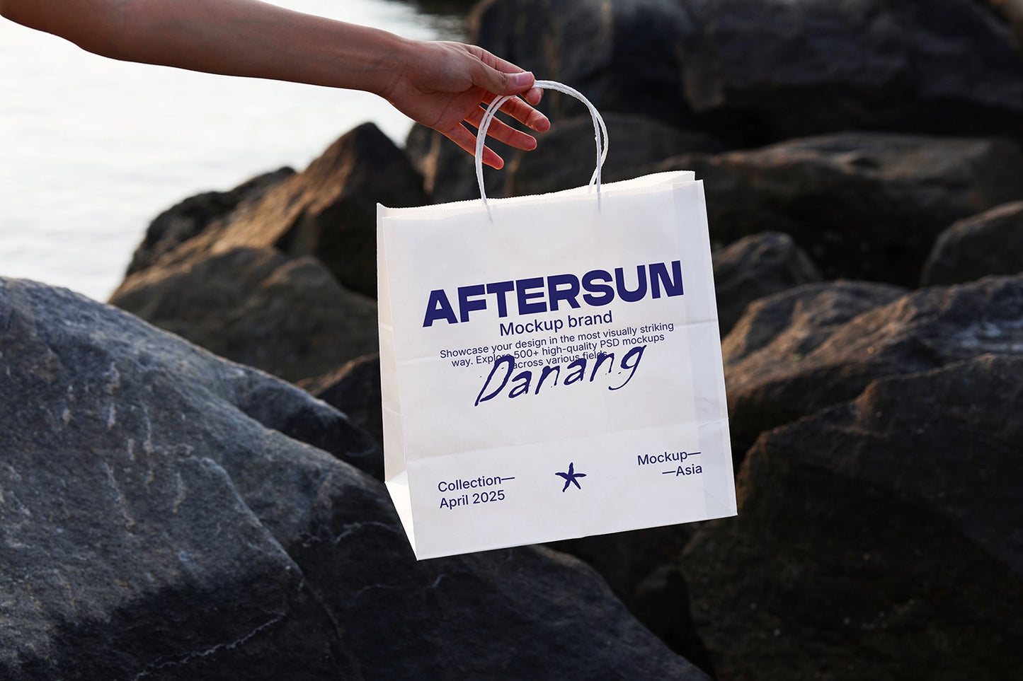 paper bag mockup held in hand on rock surface with natural sunlight and realistic shadow