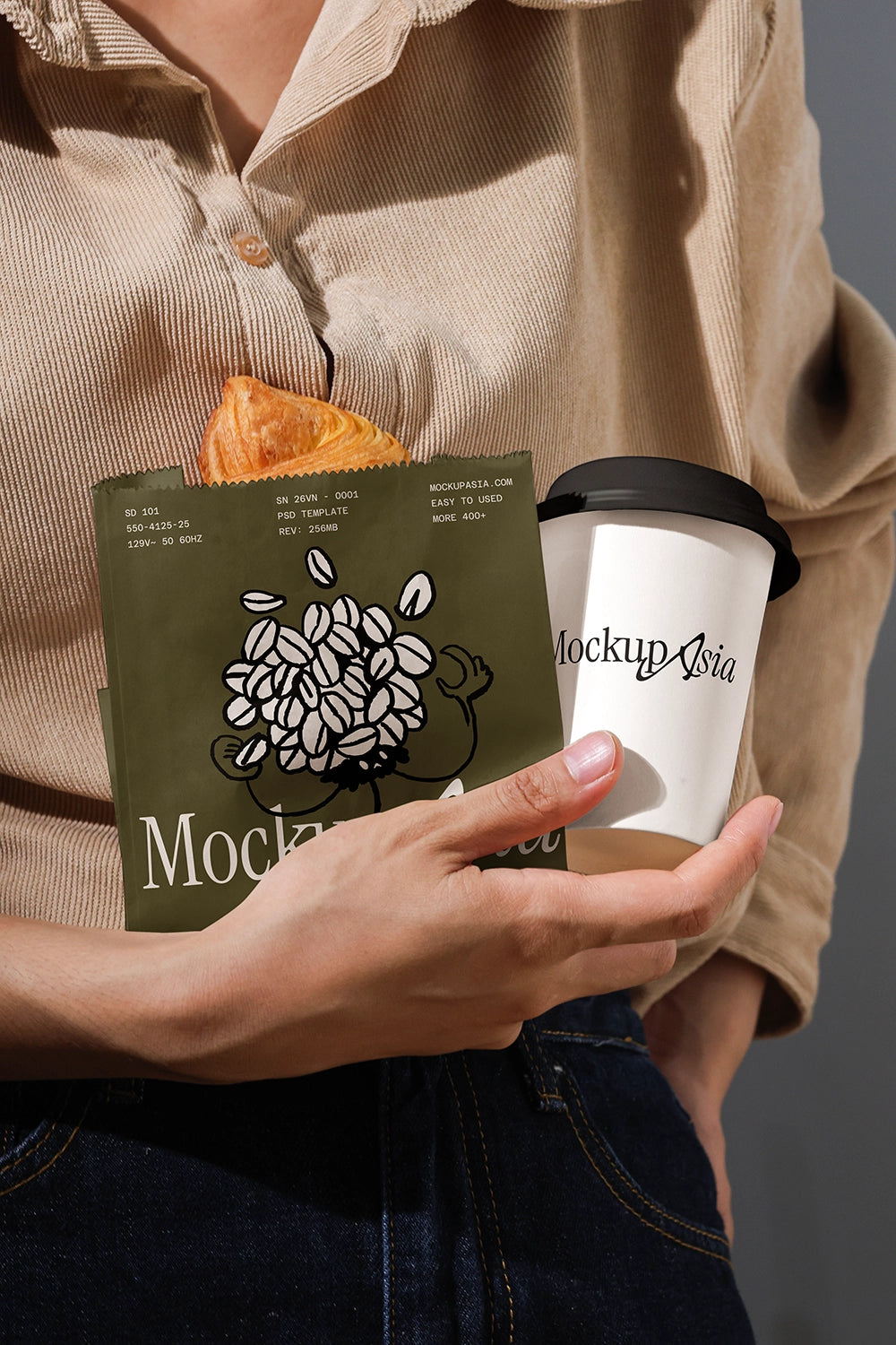 Person holding a branded coffee cup and package with a neutral background