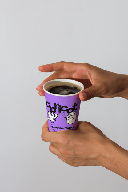 realistic paper cup mockup close-up with human hands holding coffee, minimal studio lighting