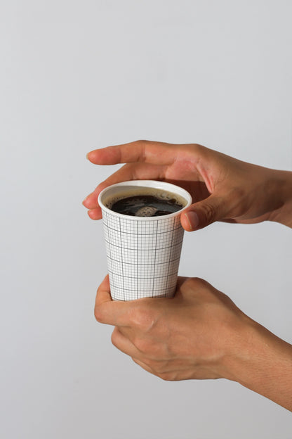 coffee cup branding mockup held by hands with black coffee inside, clean and modern presentation