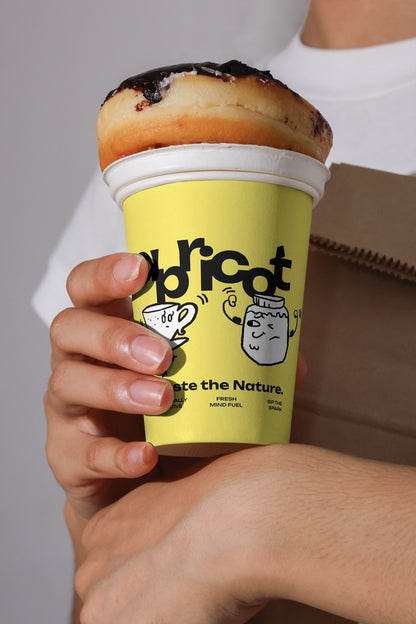 disposable coffee cup mockup with donut placed on top, minimal branding and lifestyle close-up
