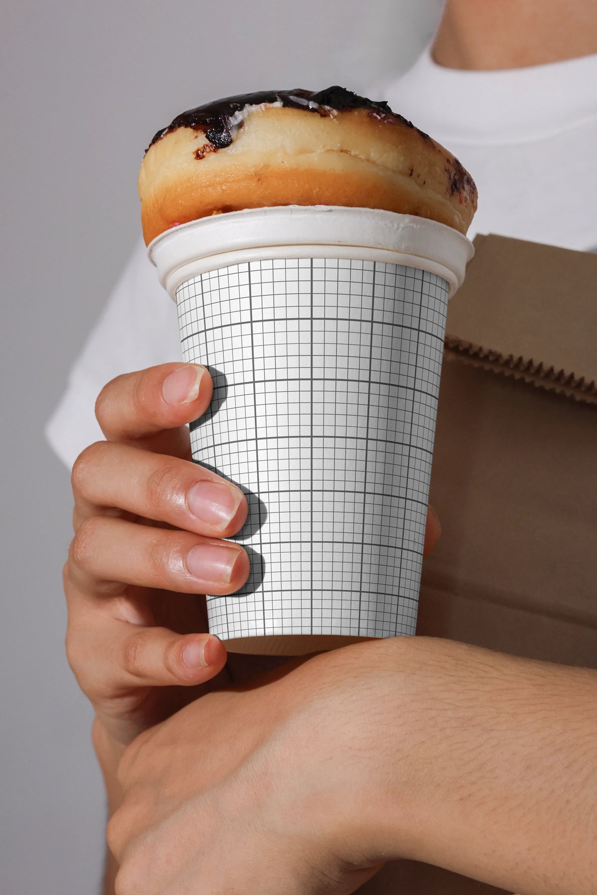creative coffee cup mockup with pastry lid concept held in hands, modern cafe packaging template