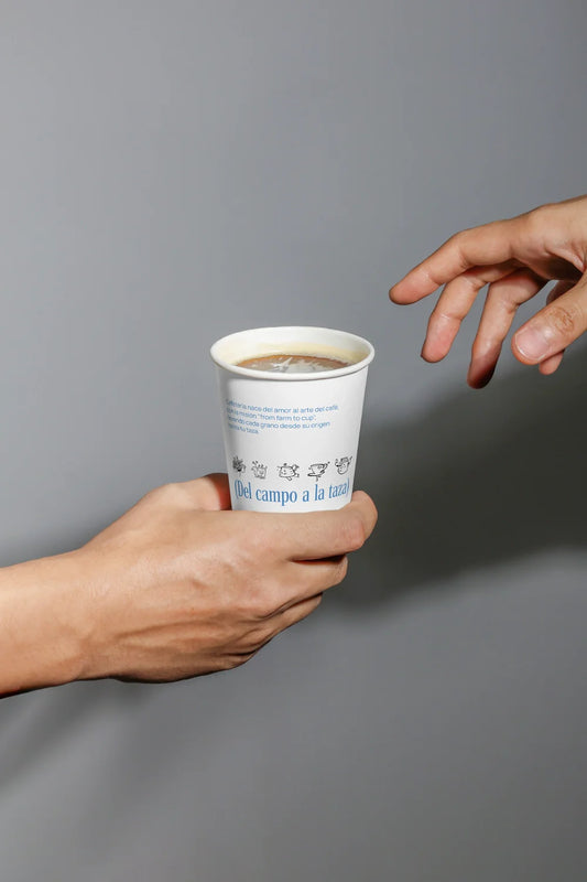 paper coffee cup mockup with hands passing drink, minimal background and realistic lighting