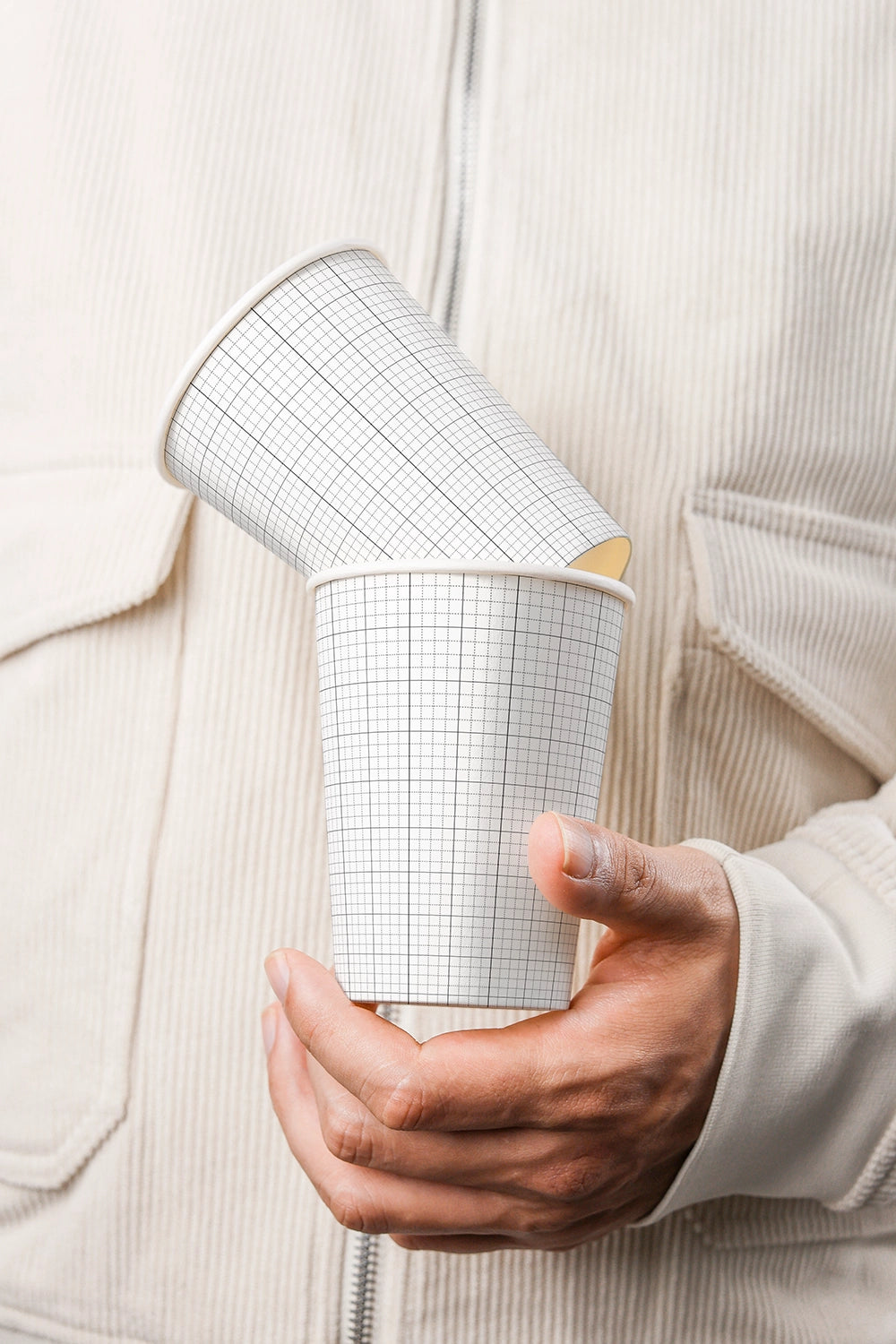 disposable cup mockup with two stacked cups in hand and soft natural lighting