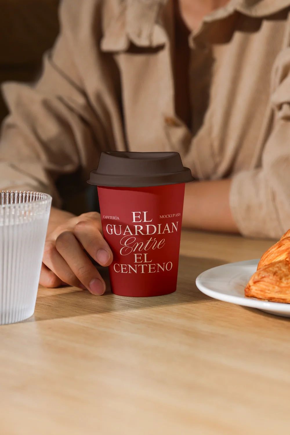 coffee cup mockup on table with person holding cup, cafe lifestyle scene