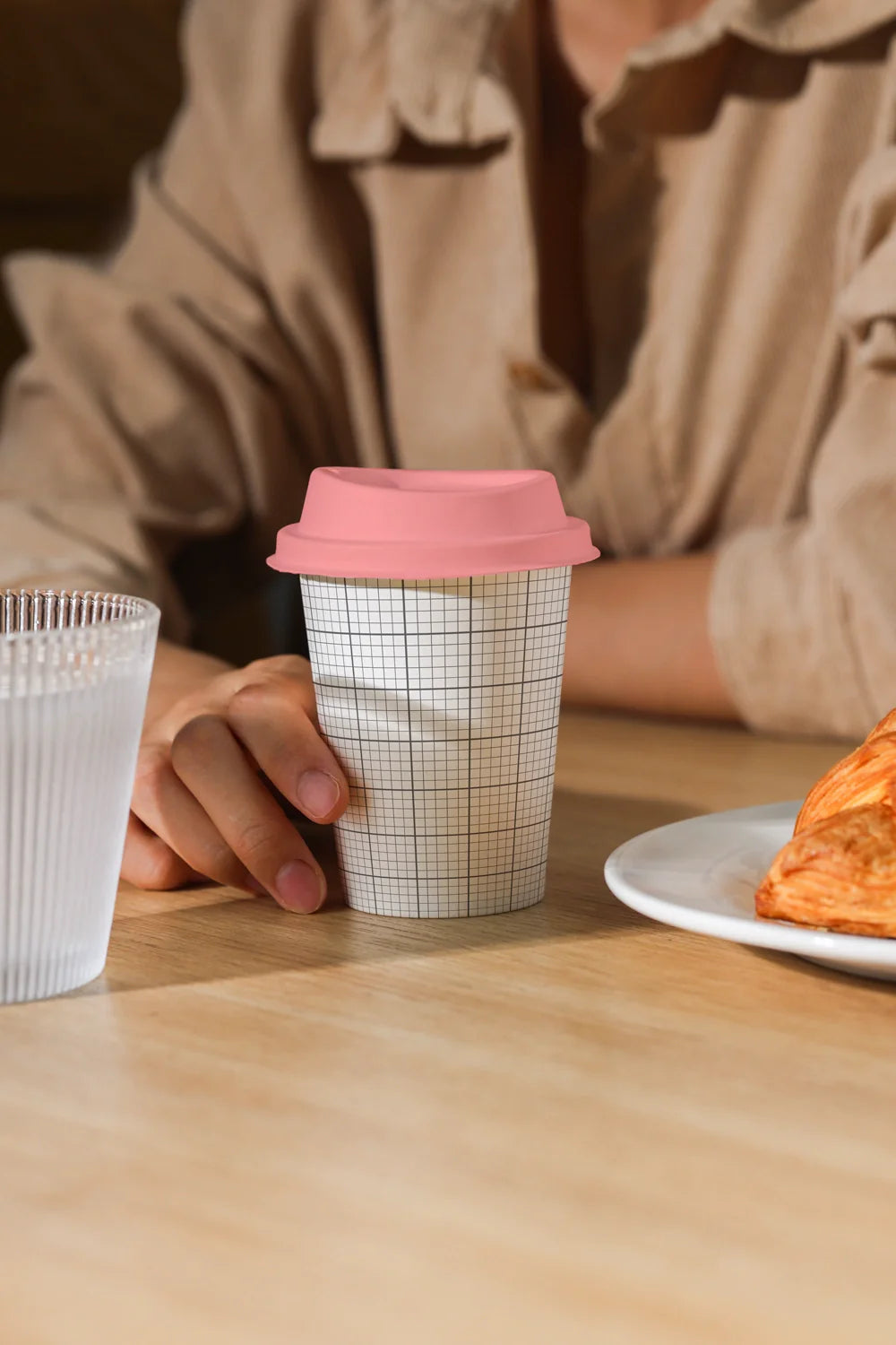 takeaway coffee cup mockup with pastry and drink, warm lighting cafe setting