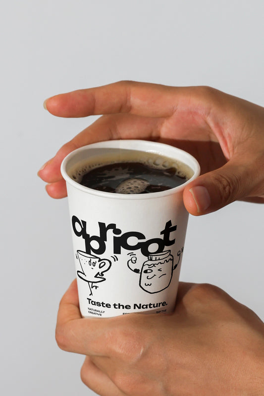 paper coffee cup mockup held in hands with black coffee, minimal branding close-up scene