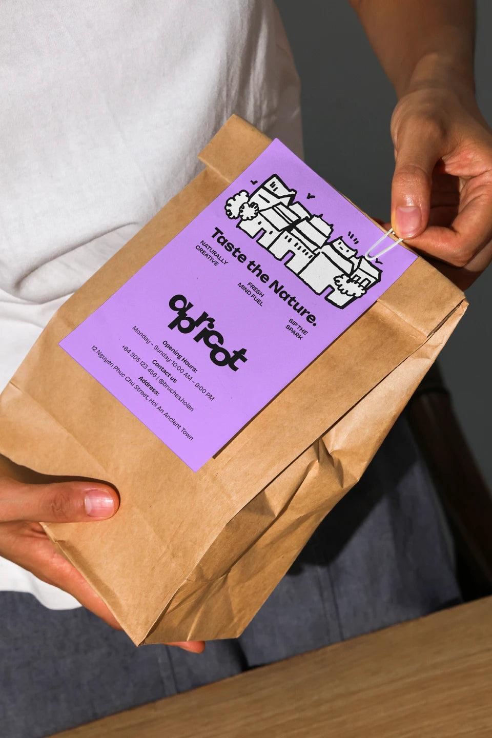 kraft pouch mockup with branding label in hands, clean and natural lighting setup