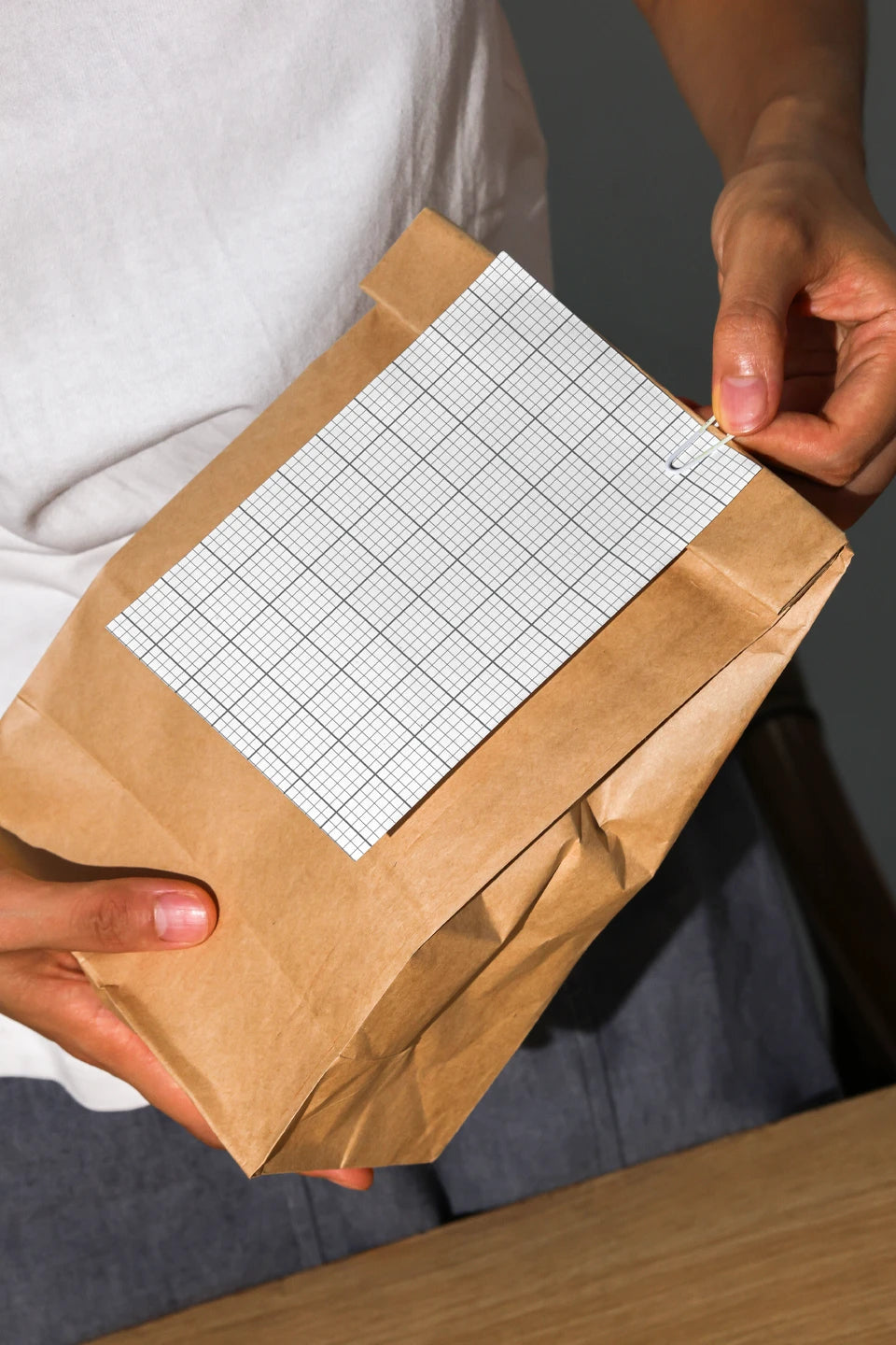 paper packaging bag mockup with label held by person, modern minimalist branding template