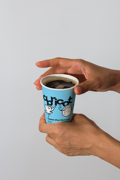 Paper coffee cup with Apricots Coffee Collection bundle label from Mockup.Asia, featuring a printed design on the cup.
