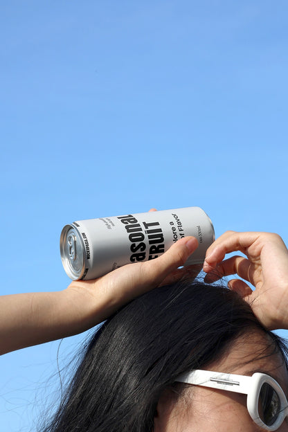 Soda can mockup resting on head with hand and sunglasses under blue sky lifestyle beverage branding