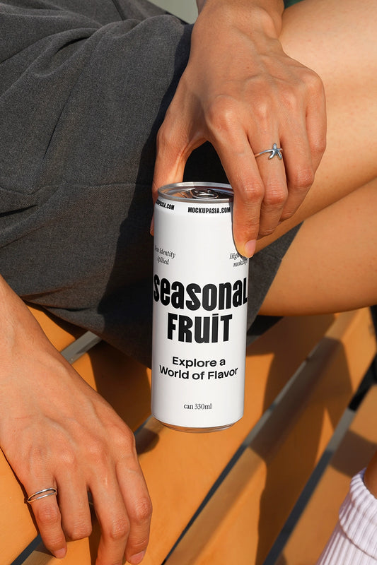 Close-up soda can mockup held by hand on outdoor bench with natural sunlight and shadows