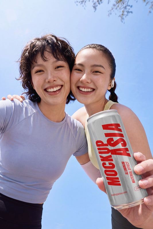 Sleek aluminum can mockup held by two smiling models outdoors
