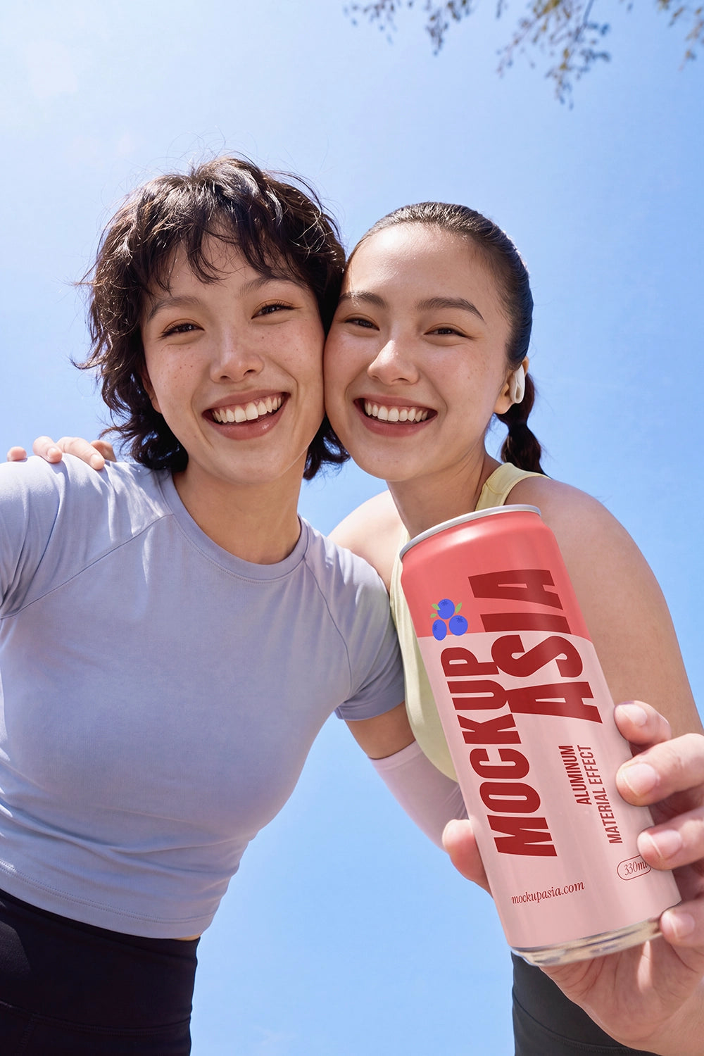 Two friends holding a metallic sleek beverage can mockup against blue sky