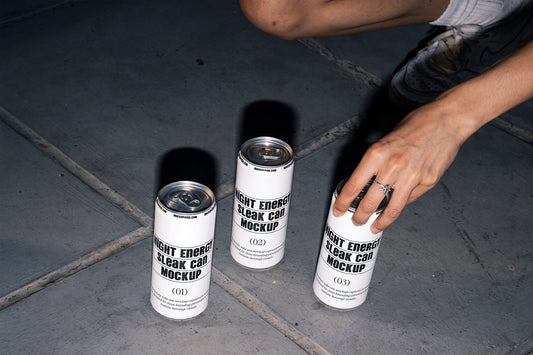 Three slim aluminum cans arranged on urban concrete pavement in a lifestyle mockup.