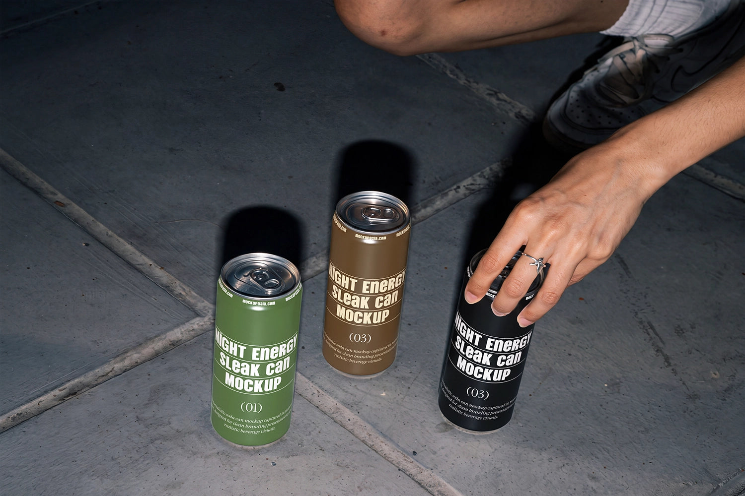 Aluminum can packaging mockup with a hand reaching toward one of three cans.