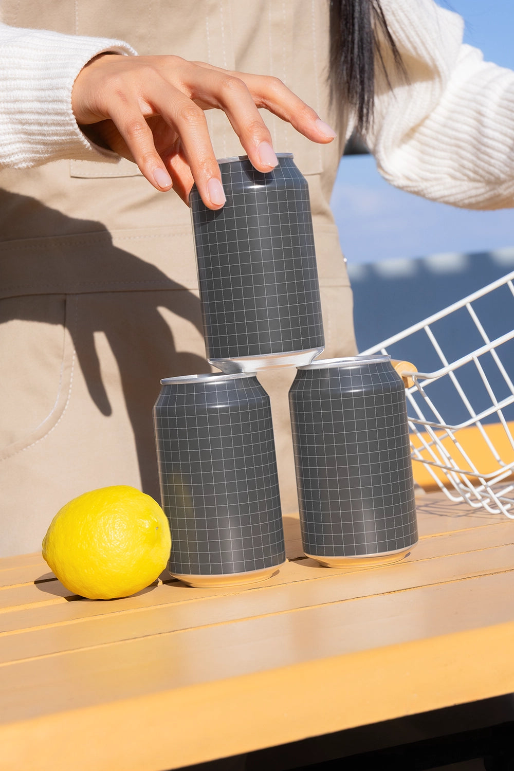 Aluminum soda can mockup three cans stacked with hand and lemon realistic lifestyle packaging PSD