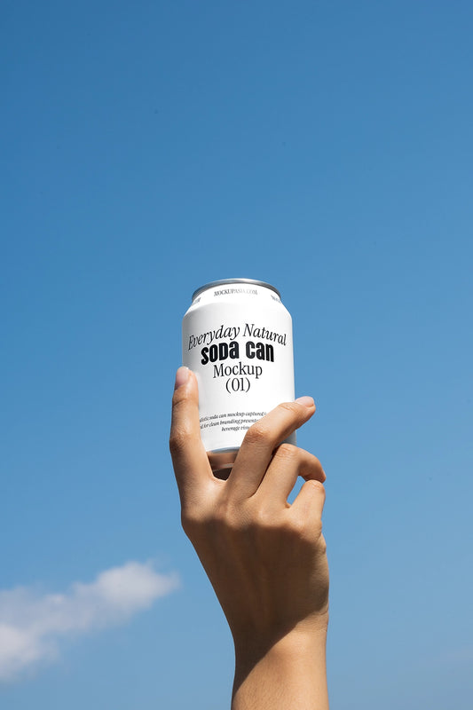 Hand holding soda can mockup against blue sky outdoor minimal lifestyle beverage packaging