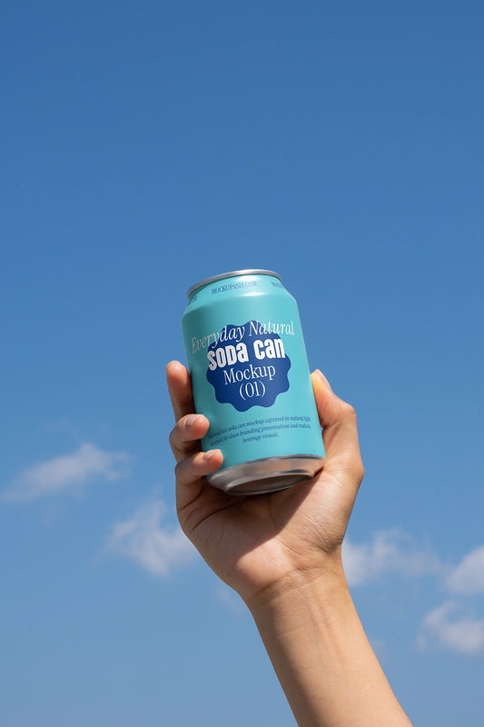 Hand holding blue soda can mockup against sky outdoor lifestyle aluminum beverage packaging