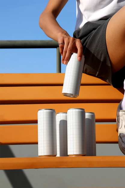 Outdoor soda can mockup with group of cans and casual hand interaction for modern beverage packaging presentation