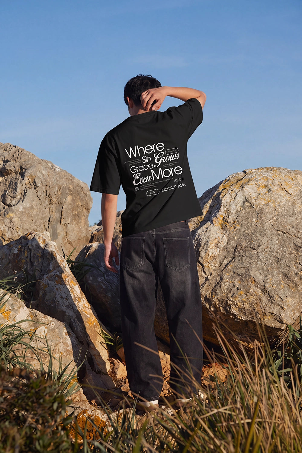 Editorial outdoor T-shirt mockup showing the back print area of an oversized white shirt under natural sunlight.