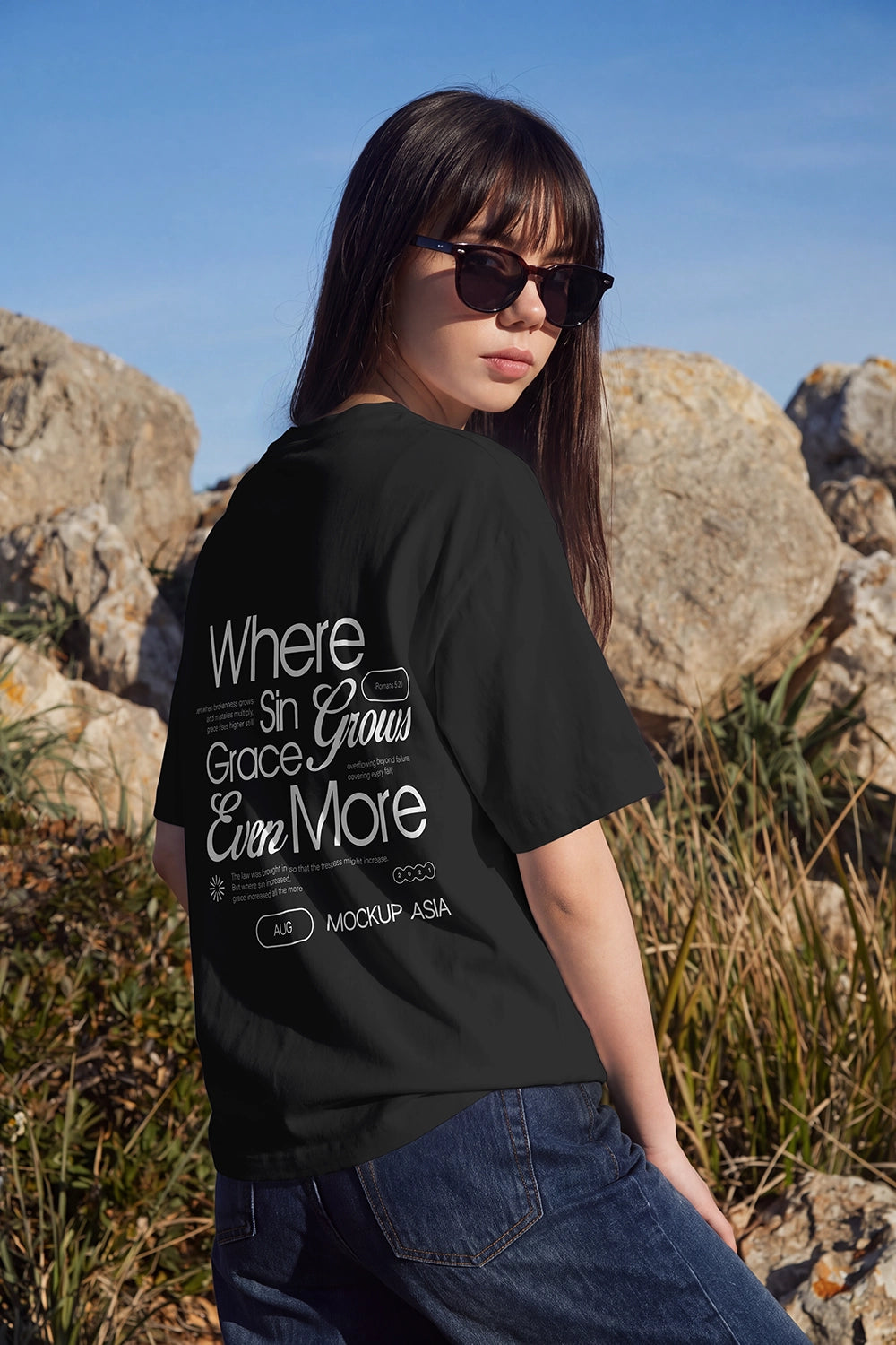 Editorial outdoor T-shirt mockup showing a large customizable back print area on a white oversized shirt.