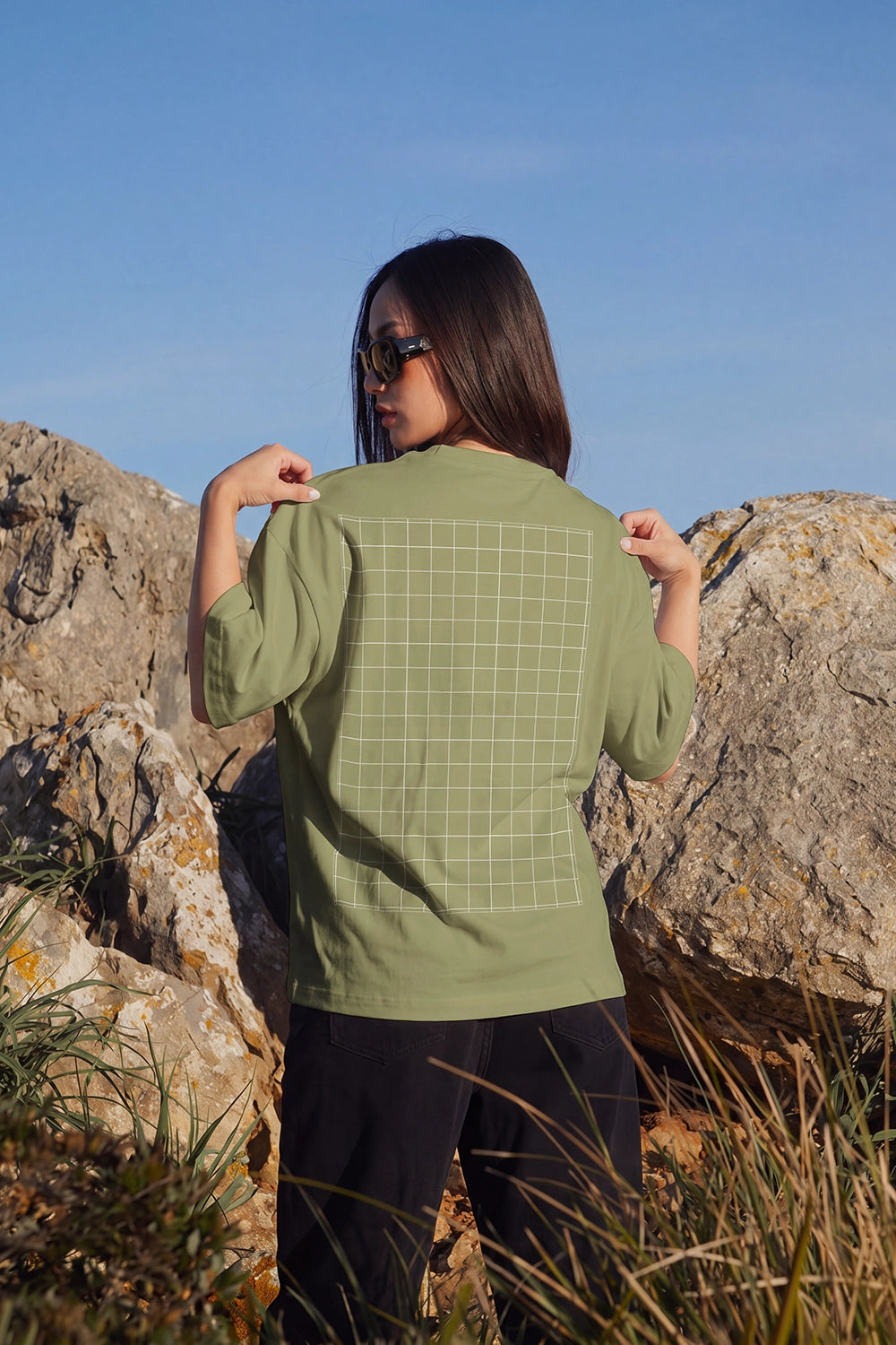 Realistic back view white T-shirt mockup between natural rocks