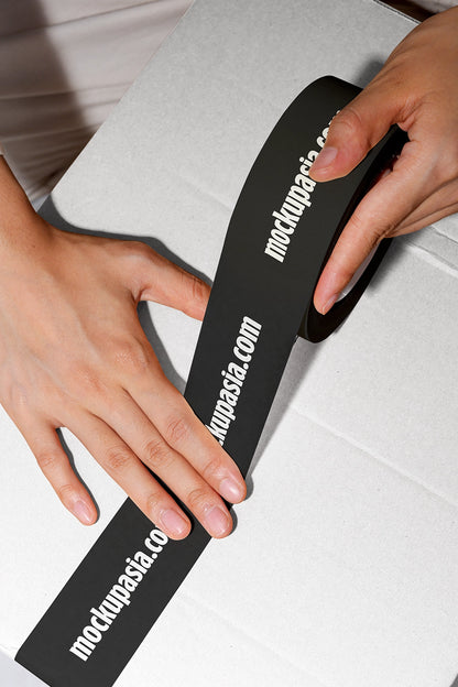 adhesive tape mockup with branding on parcel box and close up hand interaction