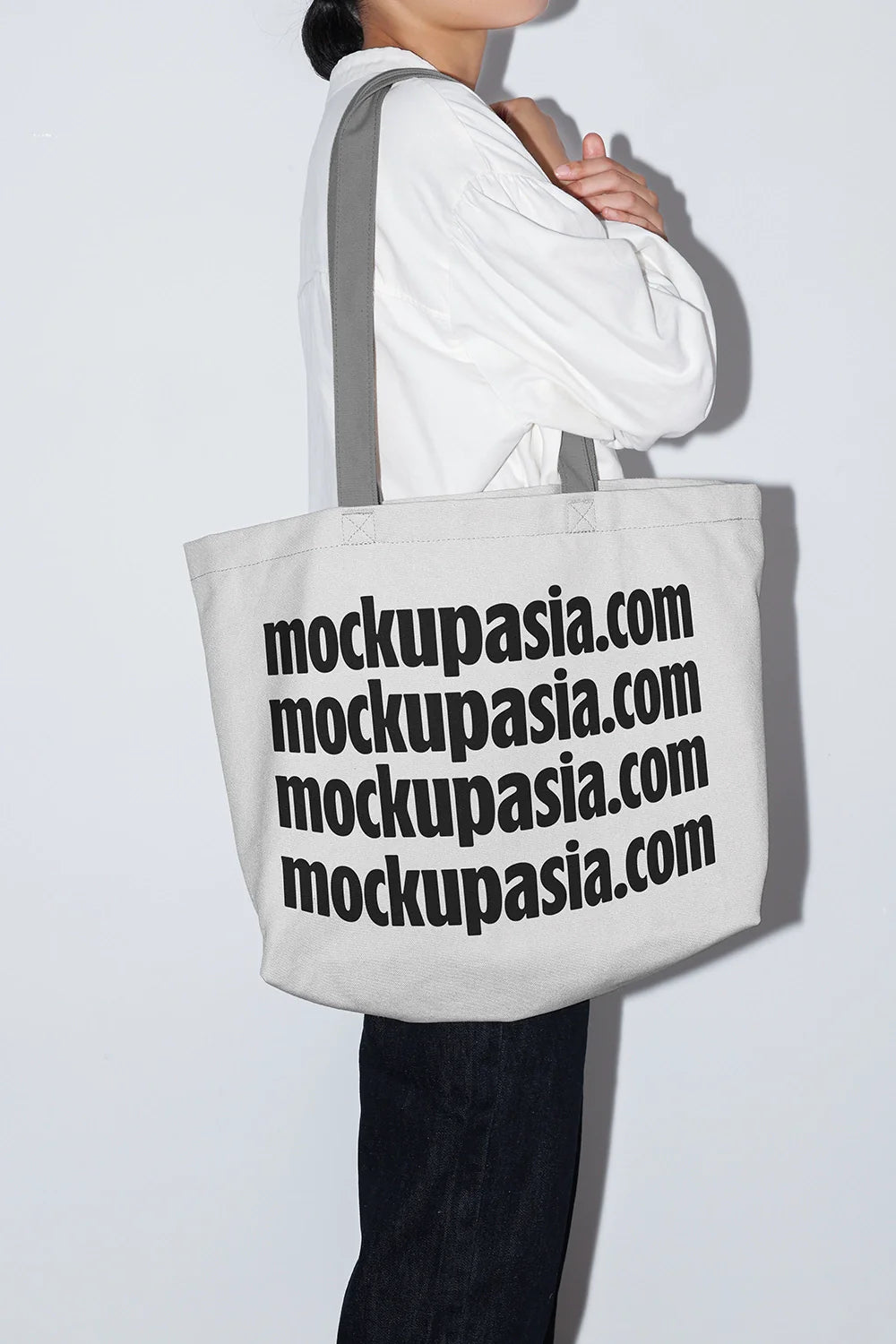 oversized canvas tote bag mockup on shoulder with bold typography design, clean studio background