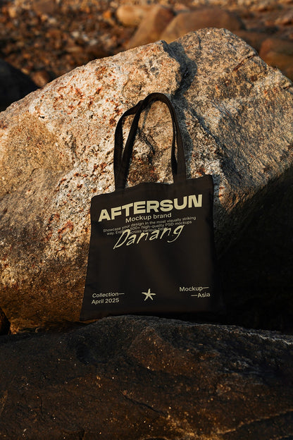 cotton tote bag mockup with logo design on rocky background, golden hour lighting