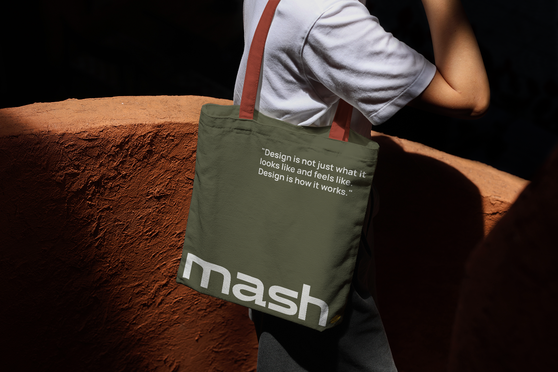 tote bag mockup carried by person, minimal branding with strong natural shadows