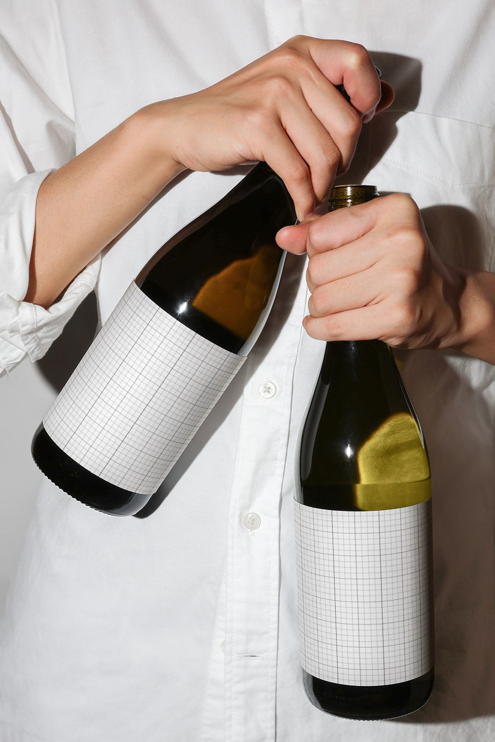 wine packaging mockup with hands holding bottles and natural lighting setup